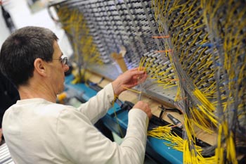 Technicians work on the 3,400 sensors to optical cables on the detector